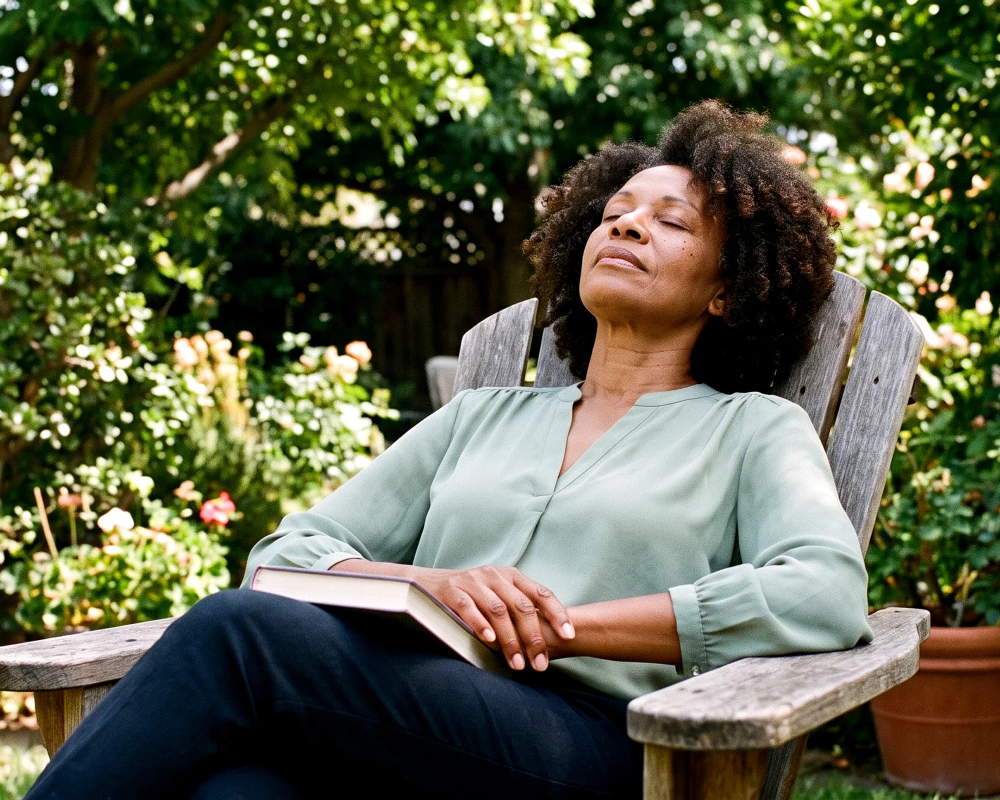 A family caregiver resting in a garden chair with a book in her lap